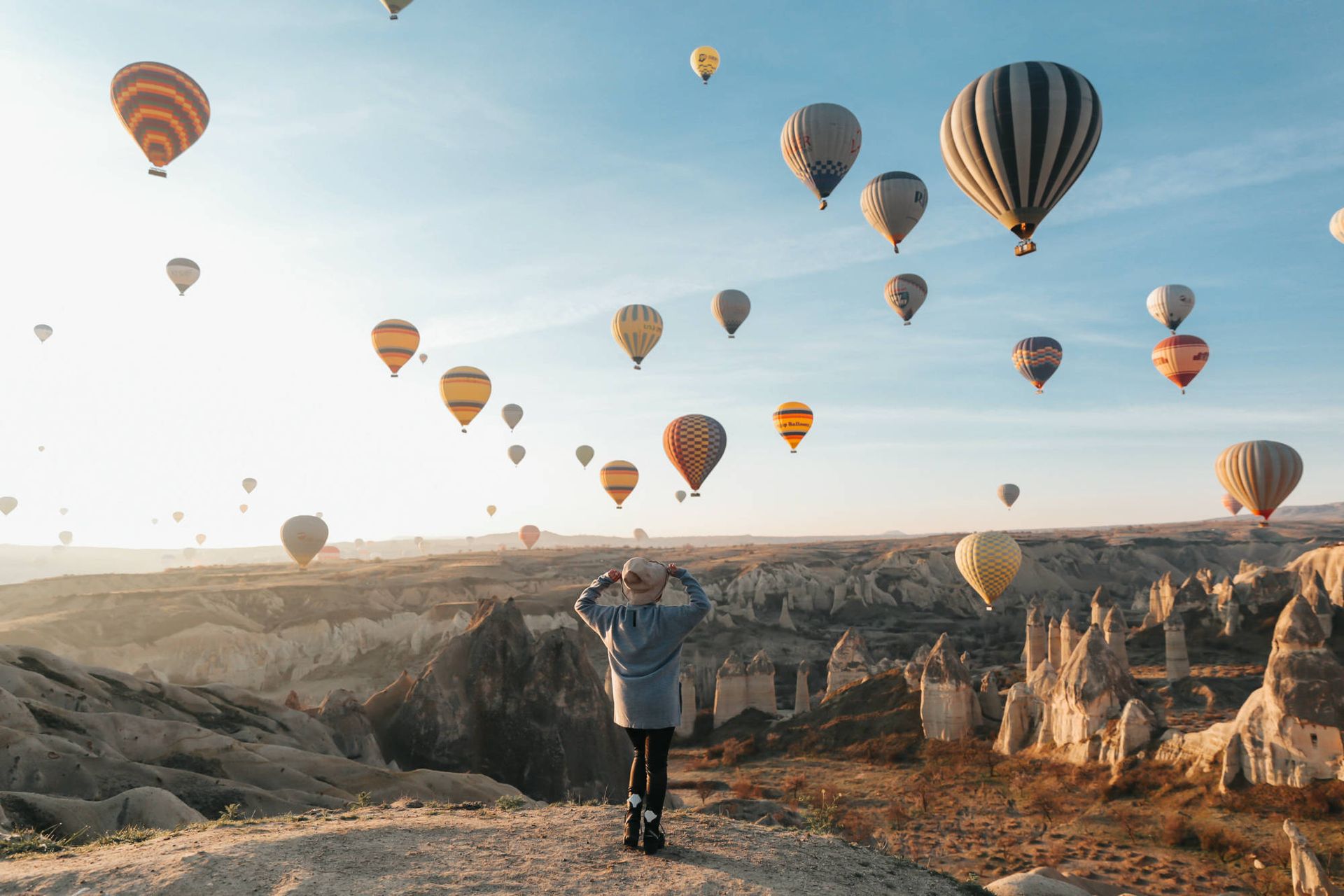 Gün doğumunda Kapadokya semalarını dolduran onlarca sıcak hava balonunu izleyen gezgin